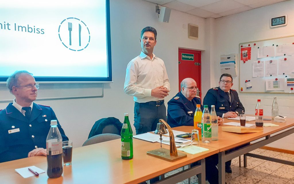 Oberbürgermeister Dr. Fabian Geyer hält eine Ansprache. Er steht hinter einer Reihe Tische.